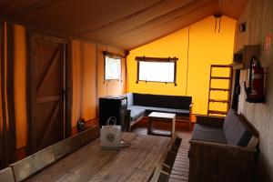 a living room with a couch and a table at Lodge in de Ijsmolenhoeve in Ronse