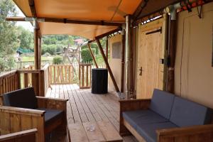 a patio with a couch and a table and a door at Lodge in de Ijsmolenhoeve in Ronse