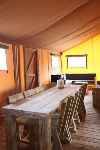a large wooden table with chairs in a room at Lodge in de Ijsmolenhoeve in Ronse