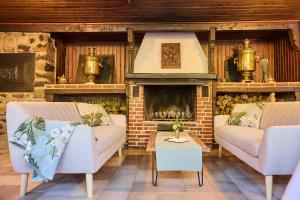 a living room with two couches and a fireplace at Hotel & Restaurant Rhönhäuschen in Bischofsheim an der Rhön