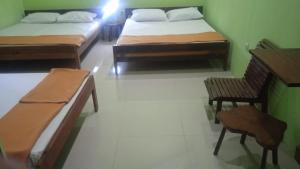 a room with two beds and a table and chairs at Oasis Homestay in Mendut