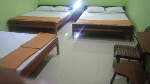 a room with two beds and a table and chairs at Oasis Homestay in Mendut
