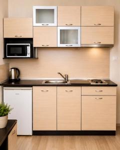 a kitchen with wooden cabinets and a sink at Hotel Topalovi in Nesebar