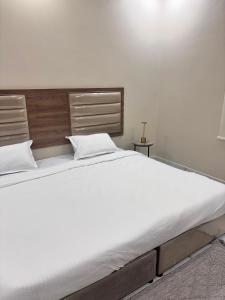 a large white bed in a white bedroom at ايراد للشقق - النور in Dammam