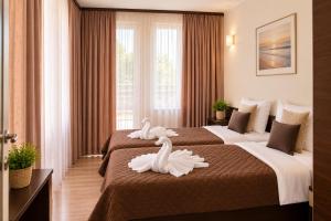 two swans on two beds in a hotel room at Hotel Topalovi in Nesebar