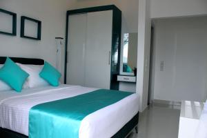 a bedroom with a large bed with blue pillows at Mount Princess in Mount Lavinia