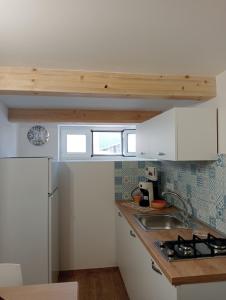 a kitchen with white cabinets and a sink at Il Fico d`India in Ispica