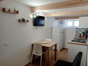 a small kitchen with a small table and a refrigerator at Il Fico d`India in Ispica +3 photos