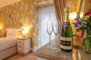 a bedroom with a bottle of wine and two wine glasses at Ty Derw B & B in Dinas Mawddwy
