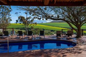 a pool with chairs and a view of a field at Skeiding Guest Farm in Heidelberg