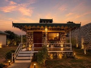 a small house with a porch with lights in the yard at Jawai Garh Resort in Bīsalpur +6 photos