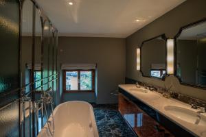 a bathroom with two sinks and a tub and mirrors at CASABIANCA Suites in Como +15 photos