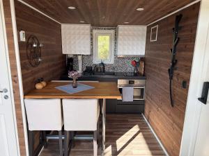 a kitchen with a table in a tiny house at Skogsviken Guesthouse in Munkedal +8 photos