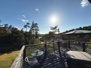 a patio with a table and chairs on a deck at Skogsviken Guesthouse in Munkedal