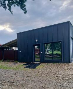 a black building with glass doors in a yard at Під Дубочком in Stebnev