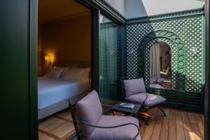 a bedroom with a bed and two chairs and a mirror at CASABIANCA Suites in Como