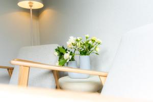 a white vase with white flowers sitting on a table at Rosengarten in Kellenhusen