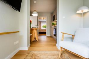 a living room with a white couch and a kitchen at Rosengarten in Kellenhusen +26 photos