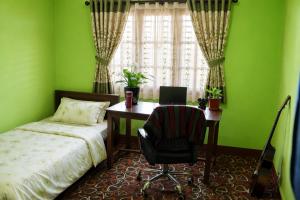 a bedroom with a bed and a desk with a computer at Sanjog's B&B in Bhaktapur