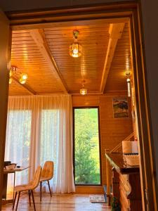 a dining room with a table and a large window at SymphonyA in Gorists'ikhe