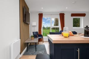a kitchen and living room with a table with orange juice on it at Cherry Lodge by Escape Ordinary in Coleraine