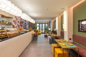 ein Restaurant mit einer langen Theke mit Tischen und Stühlen in der Unterkunft Arco Vecchio Urban Suite - Epoca Collection in Lecce