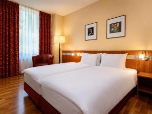 a large white bed in a hotel room at HOTEL de la POSTE in Esch-sur-Alzette