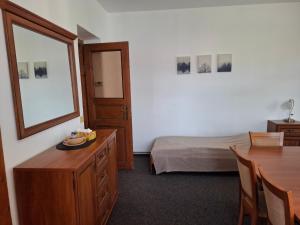 a bedroom with a bed and a table and a mirror at Penzion U školy in Staré Město