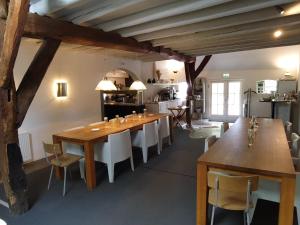 a dining room with a large wooden table and chairs at Hof van Vijfeijken in Boxtel
