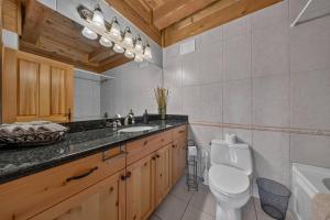 a bathroom with a toilet and a sink and a tub at Mountain View Log Home in Invermere in Invermere +41 photos