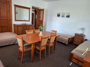 a room with a wooden table with chairs and a bed at Penzion U školy in Staré Město