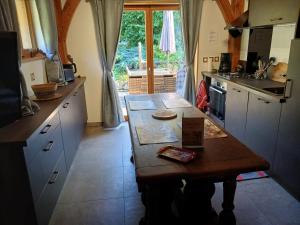 a kitchen with a wooden table in the middle at Le Rucher de St Pierre in Sainte-Marie-aux-Mines