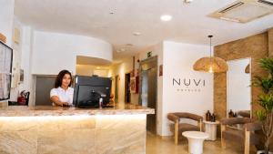 a woman standing at a counter in a store at Nuvi Mercado in Alicante