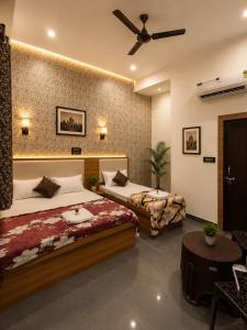 a bedroom with two beds and a ceiling fan at Hotel Town Inn in Mathura