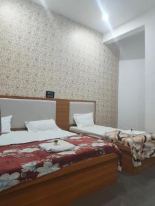 two beds sitting next to each other in a bedroom at Hotel Town Inn in Mathura