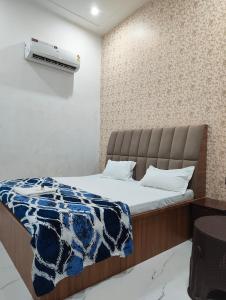 a bedroom with a bed and a air conditioner on the wall at Hotel Town Inn in Mathura +2 photos