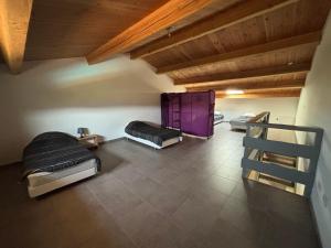 three beds in a room with a wooden ceiling at Villa Vallon Pont d'Arc in Vallon-Pont-dʼArc