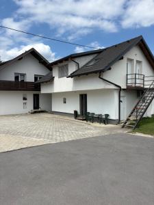 a white house with a staircase on the side of it at Apartment Harmony in Ljubljana