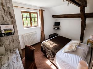 a bedroom with a bed and a window at Hotel du Golf de Clécy in Clécy