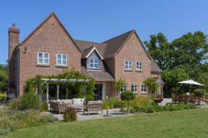 a brick house with benches in front of it at Appletree House in Sway