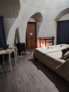 a bedroom with a bed and a table and a door at Refugio la Resiliencia in Algarrobo