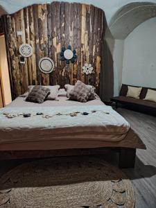 a bedroom with a bed with a wooden wall at Refugio la Resiliencia in Algarrobo
