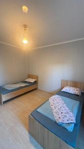 a room with two beds and a light on the ceiling at Familia Капчагай in Kapchagay