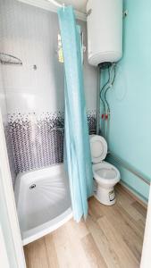 a bathroom with a toilet and a shower curtain at Familia Капчагай in Kapchagay