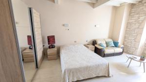 a bedroom with a bed and a couch in a room at Grande chambre avec piscine in Villeneuve-sur-Vère