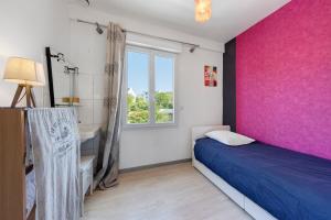 a bedroom with a pink wall and a bed and a window at Maison familiale Morgat, proche mer in Crozon