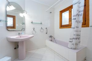 a white bathroom with a sink and a tub and a mirror at Villa 30 m from the beach Cambrils in Cambrils +18 photos