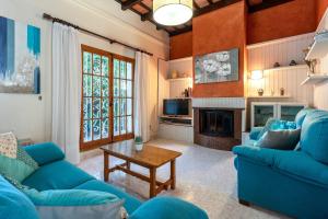 a living room with blue couches and a fireplace at Villa 30 m from the beach Cambrils in Cambrils