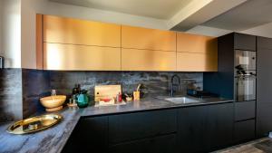 a kitchen with black cabinets and a sink at Luxury villa Mar with infinity pool in Rab in Palit