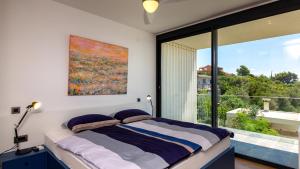 a bedroom with a bed and a large window at Luxury villa Mar with infinity pool in Rab in Palit +39 photos